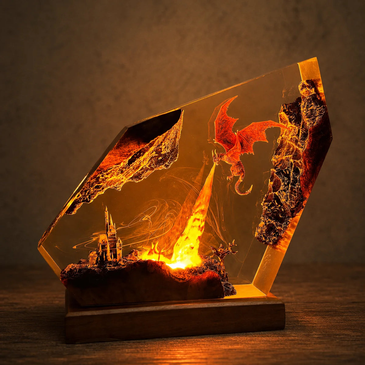 A glowing resin art piece on a wooden base, featuring a red dragon, fiery landscape, and small castle scene inside a transparent geometric block.